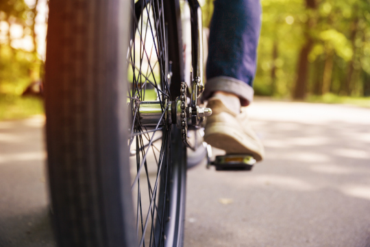 Bicycle wheel and men leg on pedal