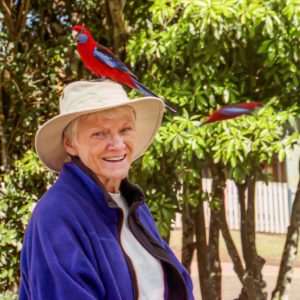 Judy Gire with a crimson rosella in Australia.